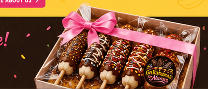 Gift box of five decorated chocolate-dipped bananas with pink ribbon